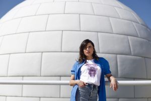 Chica apoyada en la pared ccn camiseta Smoke Aliens